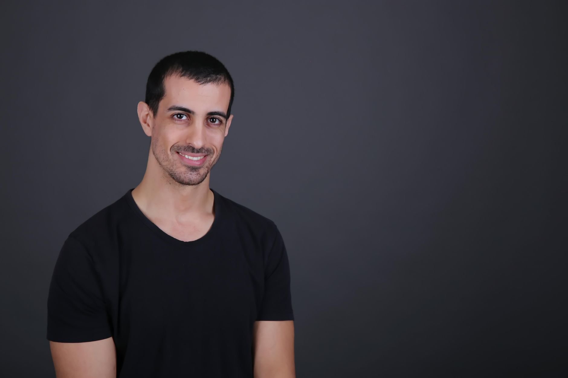 A confident on-camera presenter against a dark studio background